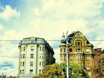 Low angle view of buildings against cloudy sky