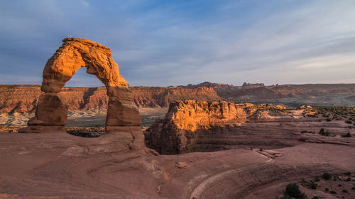 Rock formations on landscape against cloudy sky