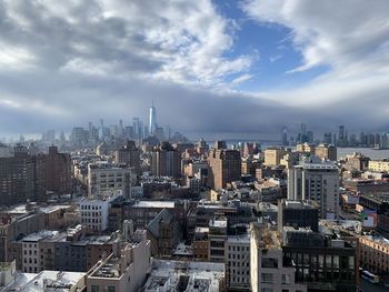 Aerial view of buildings in city against sky