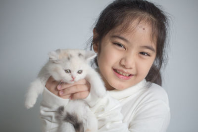 Portrait of cute girl holding kitten