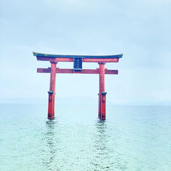 Lifeguard hut on sea against sky