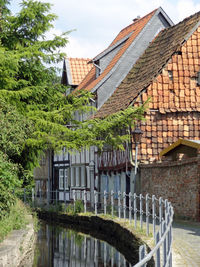 House by lake against buildings