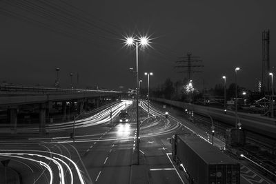 Light trails on street against sky at night