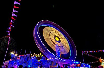 Low angle view of illuminated ferris wheel against sky at night