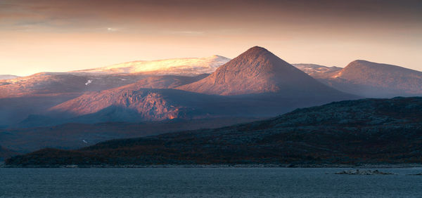 Scenic view of snowcapped mountains against sky during sunset