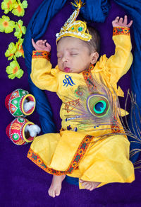 High angle view of cute baby girl sitting on bed