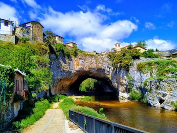 Arch bridge over river against sky