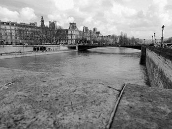 Bridge over river in city against sky