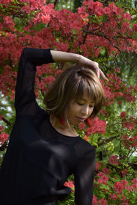 Portrait of smiling woman standing against plants