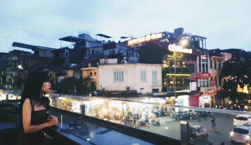 Midsection of woman on illuminated city against sky at night