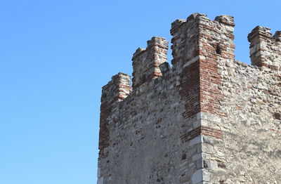 Low angle view of fort against clear blue sky