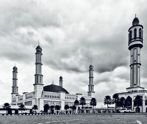 View of buildings in city against cloudy sky