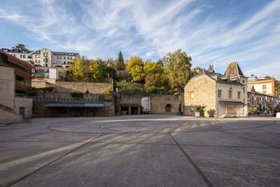 Houses by road against sky in city