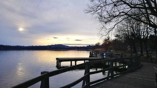 Pier on lake against sky during sunset