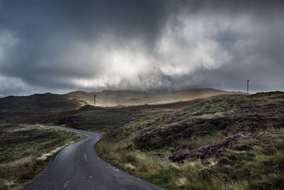 Scenic view of road by mountain against sky