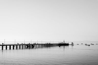 Pier on sea against clear sky