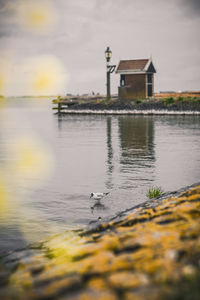 Scenic view of lake by building against sky