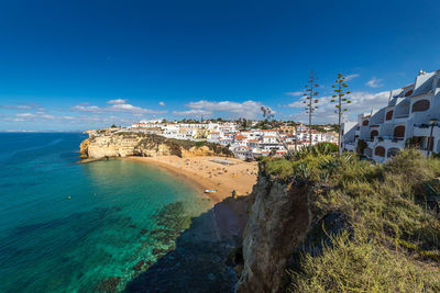 Panoramic view of sea and buildings against blue sky