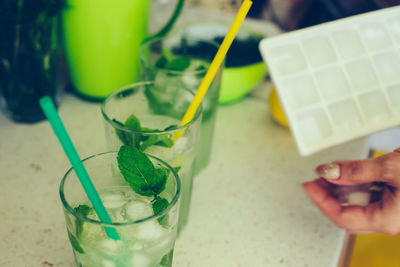 Cropped image of hand holding drink on table