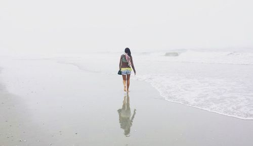 Rear view of man walking on beach