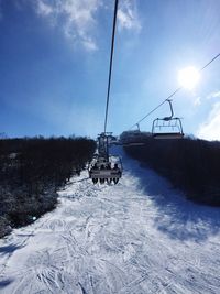 Ski lift on snowcapped mountain against sky