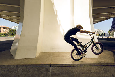 Side view of man riding bicycle on city