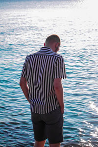 Rear view of man standing in sea