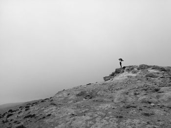 Man standing on mountain against sky