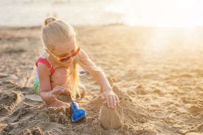 Girl playing on sand at beach