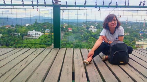 Portrait of smiling young woman sitting outdoors