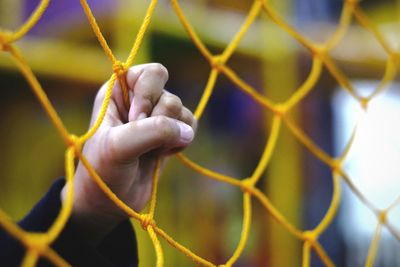 Close-up of hand on chainlink fence