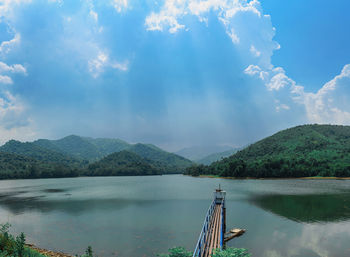 Scenic view of lake by mountains against sky