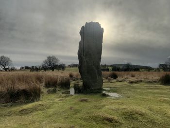 Stone wall on field against sky