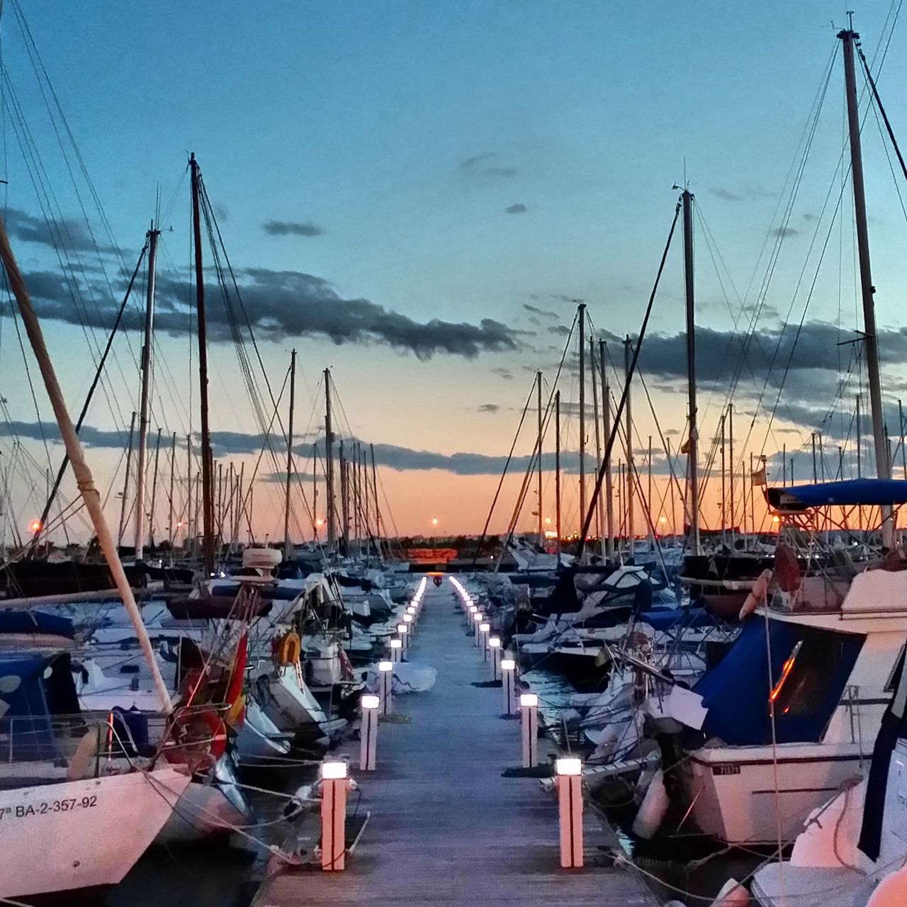 nautical vessel, moored, transportation, water, boat, mast, mode of transport, sky, harbor, sea, in a row, sailboat, diminishing perspective, the way forward, large group of objects, cloud - sky, marina, outdoors, no people, pier