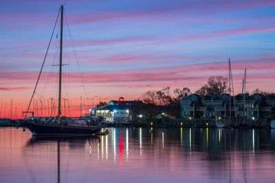 Sailboats in sea at sunset