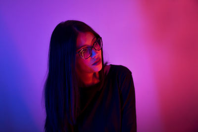 Young woman with long hair looking away