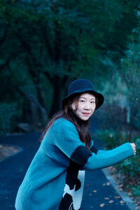 Portrait of smiling woman standing on road 