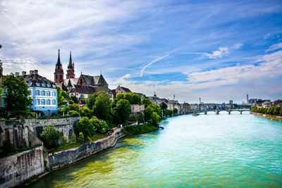 Buildings along river with buildings in background