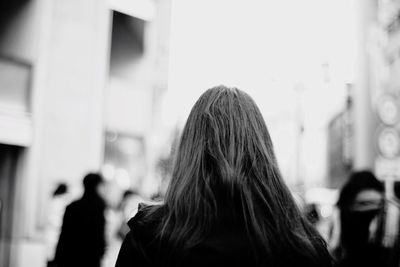 Rear view of woman standing in front of built structure