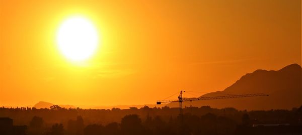 Scenic view of silhouette mountains against orange sky