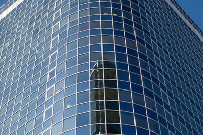 Low angle view of glass building against clear sky