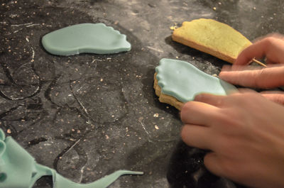 Cropped image of hands preparing biscuits at table