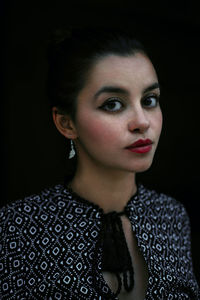 Portrait of beautiful young woman over black background