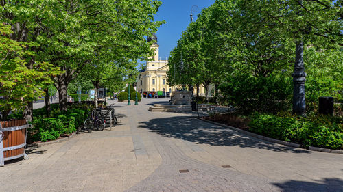 Footpath amidst trees and buildings in city