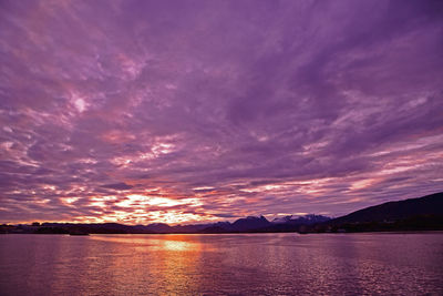 Scenic view of sea against dramatic sky during sunset