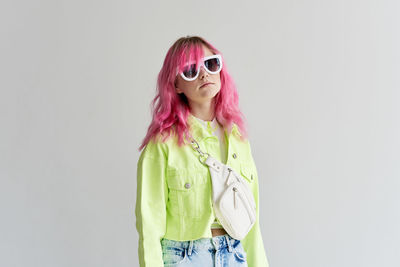 Young woman wearing sunglasses against white background