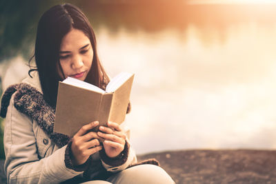 Young woman sitting on book