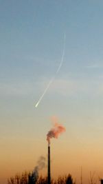 Low angle view of smoke emitting from vapor trail in sky