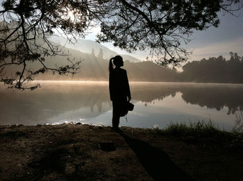 Man looking at lake against sky
