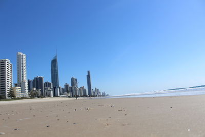 View of beach and buildings against clear sky